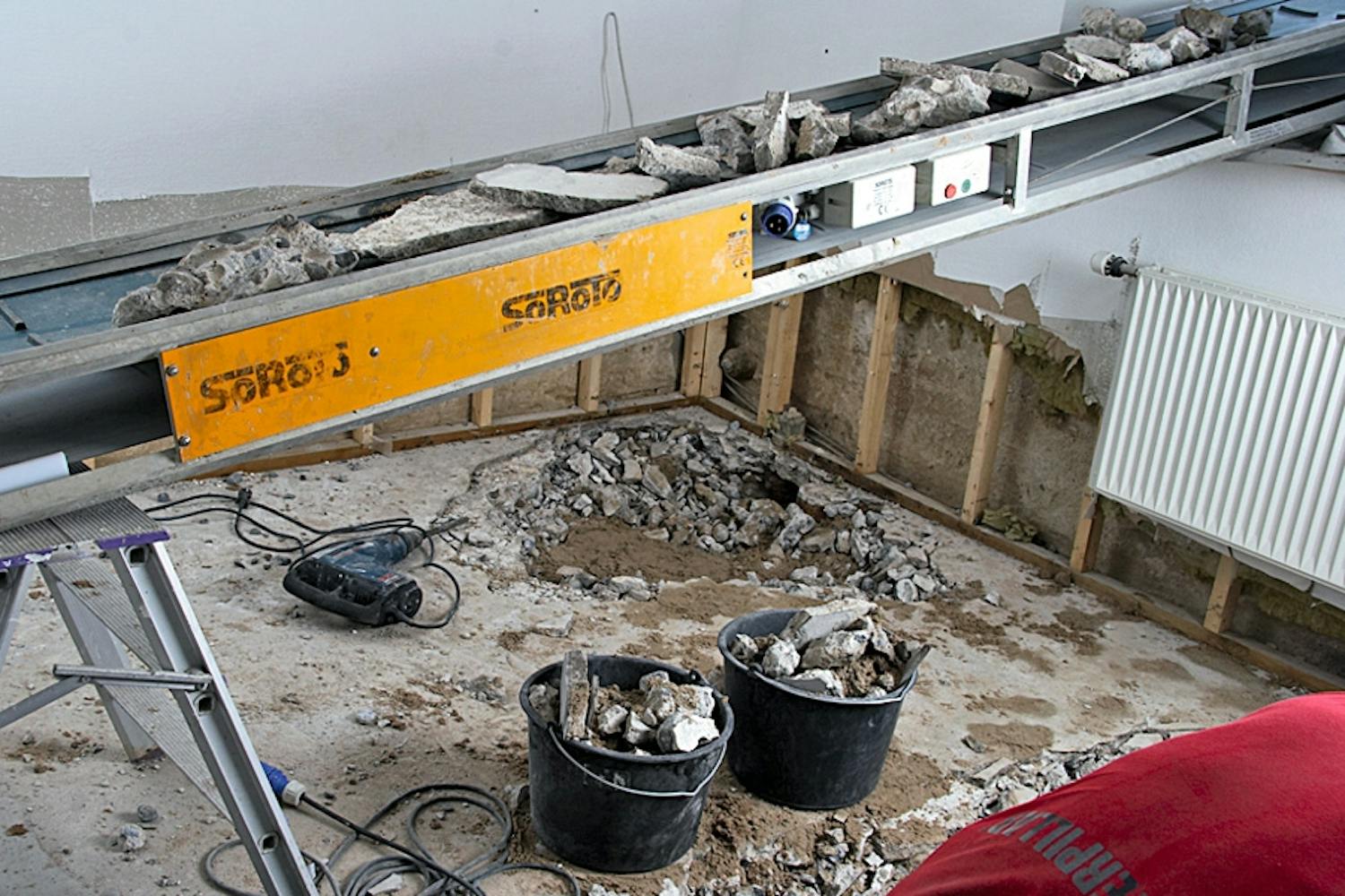 Du kan bruke hele sommerferien på å grave opp kjellergulvet og bære jord og betongrester opp gjennom trapper og entre, og videre rundt gjennom hagen – eller så kan du la transportbåndet kjøre alt gjennom vinduet og rett ut i en tilhenger. Du kan bruke hele sommerferien på å grave opp kjellergulvet og bære jord og betongrester opp gjennom trapper og entre, og videre rundt gjennom hagen – eller så kan du la transportbåndet kjøre alt gjennom vinduet og rett ut i en tilhenger.